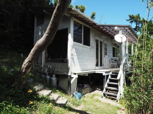 a small house with a porch and a staircase at HealingDragon Ryugu cottage in Shimoda