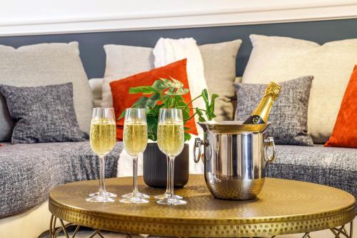- une table avec 3 verres de champagne sur un canapé dans l'établissement La Cour de l'Opera - Parking - PrestiPlace Collection, à Tours