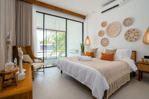 a bedroom with a bed and a large window at Villa Casa Goya - Lofty Pool Villa Near The Beach in Vibrant Legian in Legian