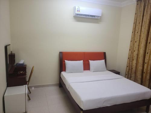a bedroom with a bed with a white mattress and a heater at Al thabit hotel apartment in Sur