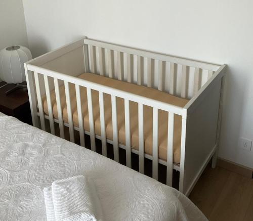 a white crib in a bedroom next to a bed at Villa Perla del Sole in Baiardo