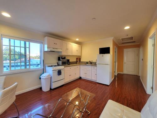 a kitchen with white appliances and a large window at 3 bedroom apartment by the MrC Hotel and 5 minutes to Rodeo Drive WiFi TV Patio walk to restaurants in Los Angeles