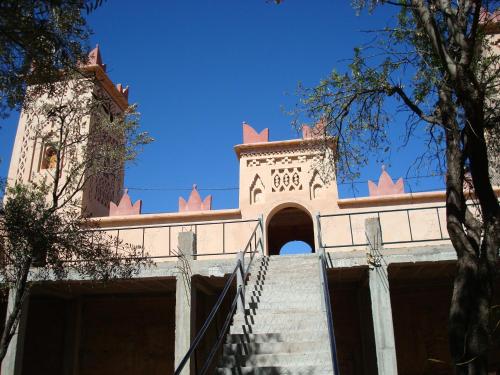 a building with stairs leading up to a tower at Kasbah Ait Kassi in Boumalne