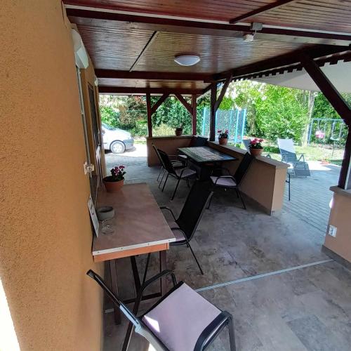 a patio with a table and chairs under awning at Boglárka Horgásznyaraló in Gyomaendrőd
