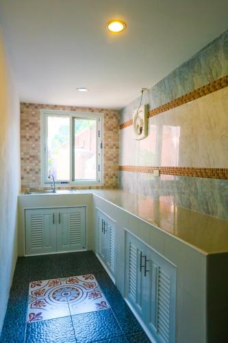 a bathroom with a tub and a sink and a window at Phalaburi resort by dreamhouse in Ban Phala