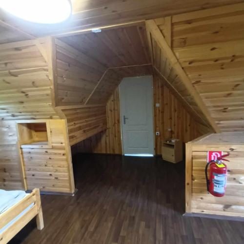 a log cabin with a bed and a room at Boglárka Horgásznyaraló in Gyomaendrőd