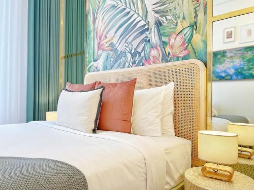 a bedroom with a bed with pillows and a painting at Studio 524- Stylish Urban Retreat on Central Queen Street in Auckland