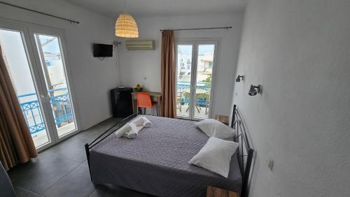 a bedroom with a bed and a balcony at Very-Kokkos Pension 2 in Naxos Chora