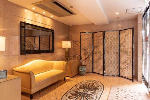 a living room with a yellow couch and a mirror at ホテルピュリッツァー自由が丘 in Tokyo