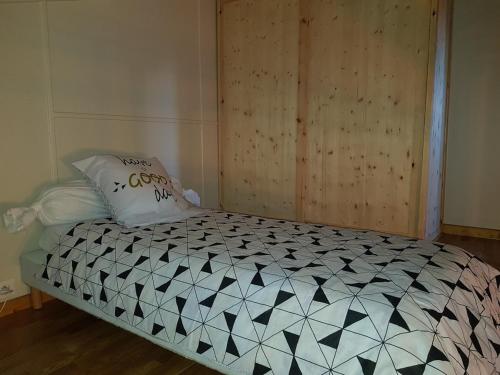 a bedroom with a bed with a black and white comforter at Chalet sur les hauteurs des Angles in Les Angles
