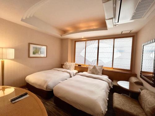 a hotel room with two beds and a table at ホテルピュリッツァー自由が丘 in Tokyo