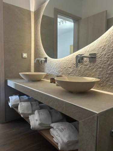 a bathroom with two sinks and a large mirror at Agathia Resort in Schinoussa