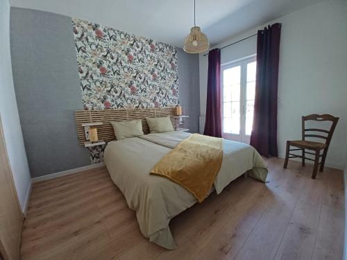 - une chambre avec un lit orné d'un mur fleuri dans l'établissement Le Fournil de Douasse, à Puycalvel Lautrec