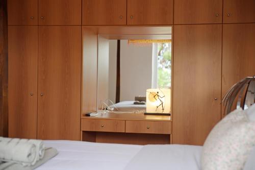 a bedroom with a bathroom with a sink and a mirror at Sunset Sea View Maisonette Anavissos in Anavissos