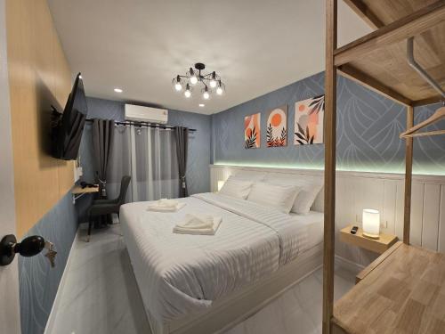 a bedroom with a bed and a desk and a television at The Bliss House Bangsaen in Ban Laem Thaen