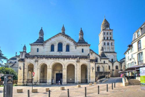 an old building with a clock tower in a city at Apparts Limogeanne - Clim - Centre historique in Périgueux