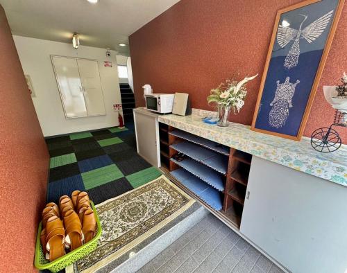 a room with a counter with a bunch of shoes at ビジネスホテル美咲 in Sakaide