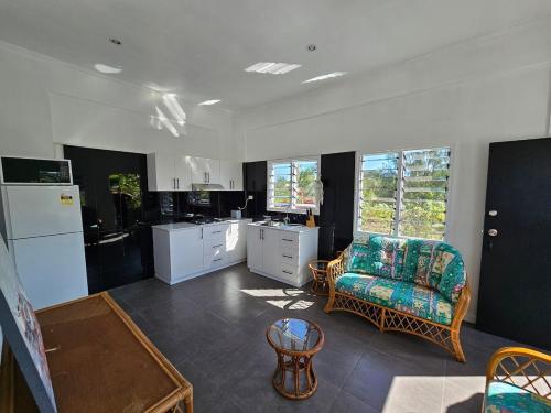 a kitchen with a couch and a chair in a room at Cosy one bedroom self contained apartment in Yandua