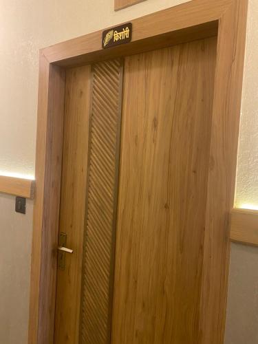 a wooden door with a sign on top of it at Radhe Krishna Residency Nearest Triveni Sangam in Prayagraj