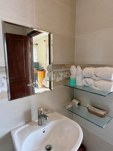 a bathroom with a sink and a mirror at Ngũ Long Hai Hotel in Vĩnh Long