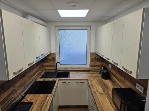 a large kitchen with a sink and a window at Penzión LABA in Trebišov