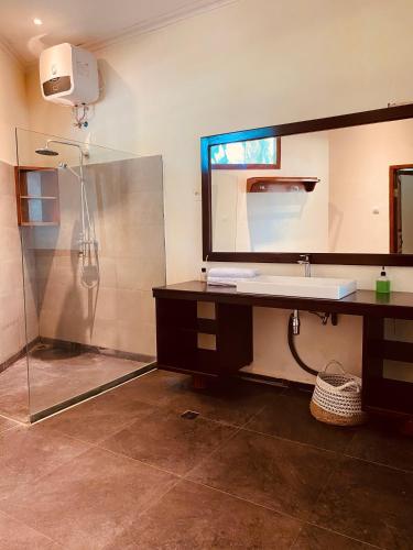 a bathroom with a sink and a shower at Sunmoon Beach Resort Likupang Timur in Pulau Mogogimbun