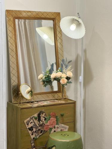 a mirror on top of a dresser with a vase of flowers at 3 Bedroom NORDIC HOME Full Kitchen 8 MINS to MRT & JODD Fair & near RCA in Bangkok