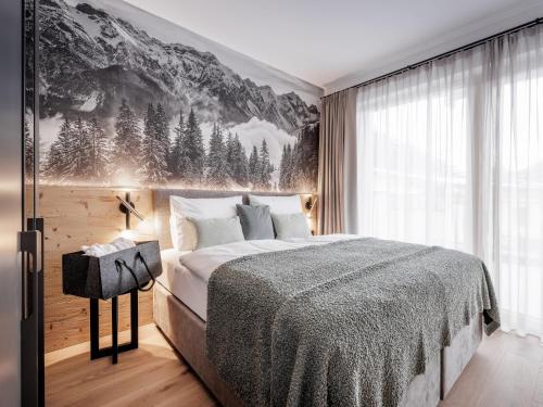a bedroom with a bed with a mountain mural on the wall at Leni Mountain Lodge in Sölden
