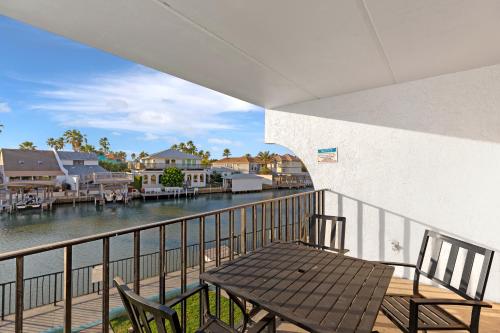 a table and chairs on a balcony with a view of the water at WindWater Hotel and Marina in South Padre Island