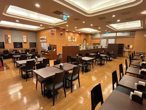 an empty dining room with tables and chairs at Hotel Route-Inn Asahikawa Ekimae Ichijodori in Asahikawa