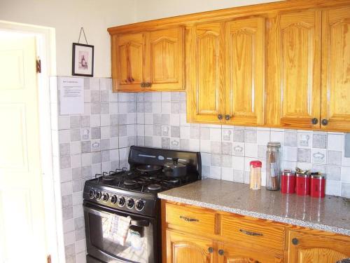 a kitchen with wooden cabinets and a stove top oven at Almond tree villa in Ocho Rios