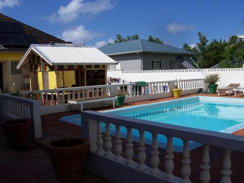 a swimming pool with a fence and a house at Almond tree villa in Ocho Rios