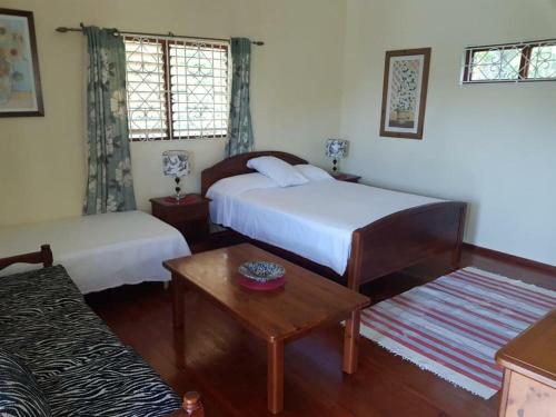 a hotel room with two beds and a table at Almond tree villa in Ocho Rios