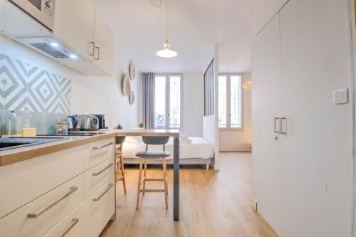 a kitchen with a table and a bed in a room at Apparts Limogeanne - Clim - Centre historique in Périgueux