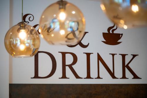 a sign for a coffee shop with lights and a drink sign at Haus Friedrich in Gosau