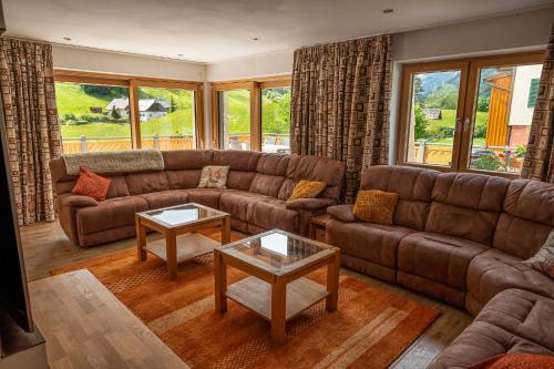 a living room with a brown couch and tables at Haus Friedrich in Gosau