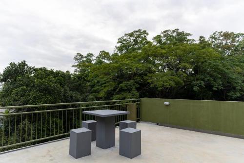 a table on a balcony with trees in the background at Greenwood Edge Kandy in Kandy