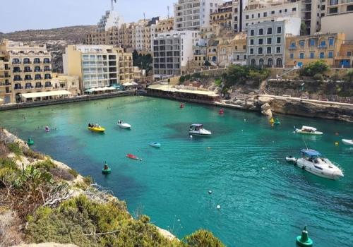 a group of boats in a river in a city at Gozo Xlendi Coastal Apartment with Stunning Sea View, Free Private Parking, AC & WiFi in Xlendi