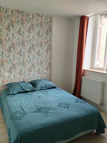 - un lit avec une couette bleue dans une chambre dans l'établissement Chez Coralie et Jean, à Saint-Pierre-Montlimart