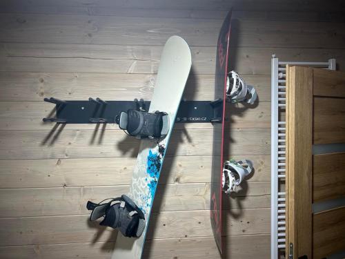 a snowboard on the floor next to two cameras at Apartmány Dolina in Demanovska Dolina