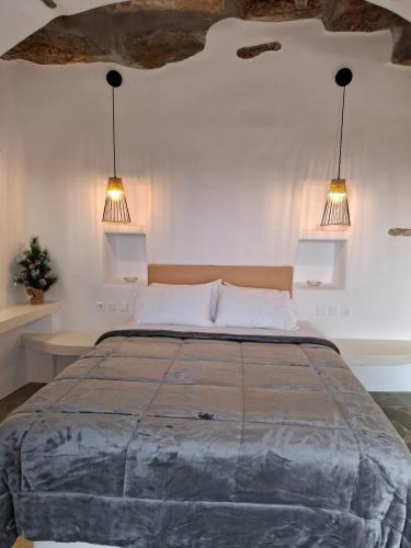 a bedroom with a large bed with two lights at Sea Melody Tinos in Agios Sostis