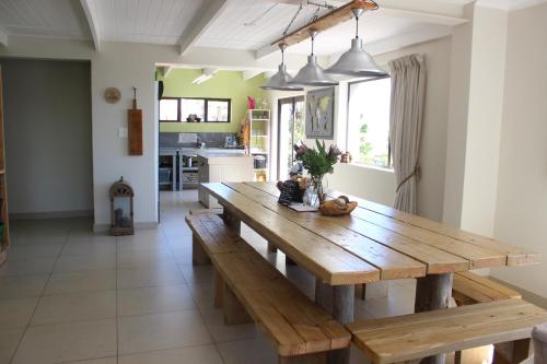 a dining room with a wooden table in a kitchen at @ Rosie's in Bloubergstrand