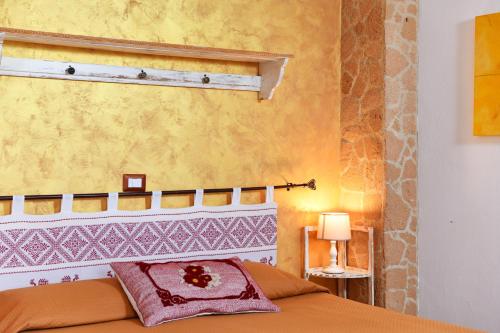 Un dormitorio con una cama y una pared amarilla. en Fattoria La Traccia, en Fertilia
