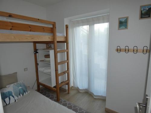 une chambre avec un lit superposé et une fenêtre dans l'établissement Le Refuge du Tilhos, à Argelès-Gazost