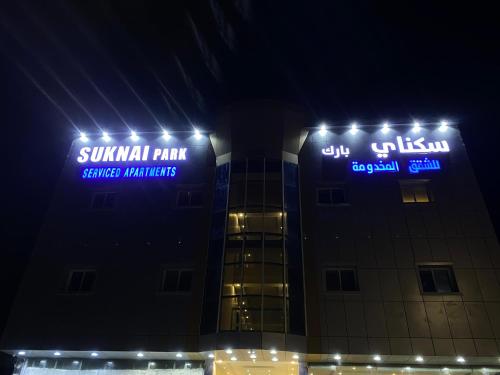 a building with lit up signs on it at night at سكناي بارك للشقق المخدومة in Arar