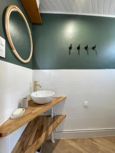 une salle de bain avec un lavabo et un miroir au mur dans l'établissement Maison de ville idéalement située à Châtel-Guyon, à Châtel-Guyon