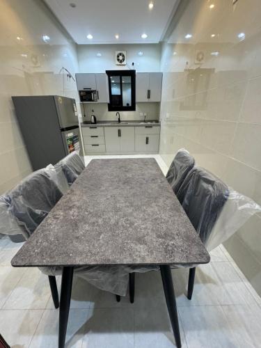 a kitchen with a table and chairs in a room at غرفه وصاله ومطبخ بأثاث فندقي جميل in Jeddah