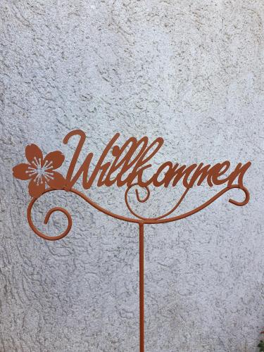 a sign that says wilderness with a flower on it at Ferienwohnung Pfotenglück nahe Ostsee mit atemberaubender Dachterrasse & Gartenblick in Mallentin