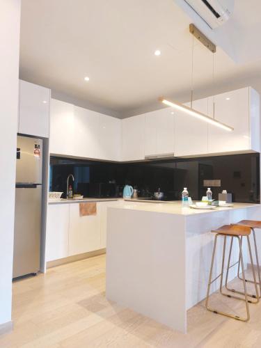 a kitchen with white cabinets and a white counter top at STAR Residences Popular By KLCC in Kuala Lumpur