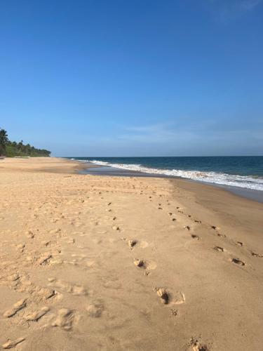 a pair of footprints in the sand on a beach at Seth Villa by Magampura Resorts in Tangalle